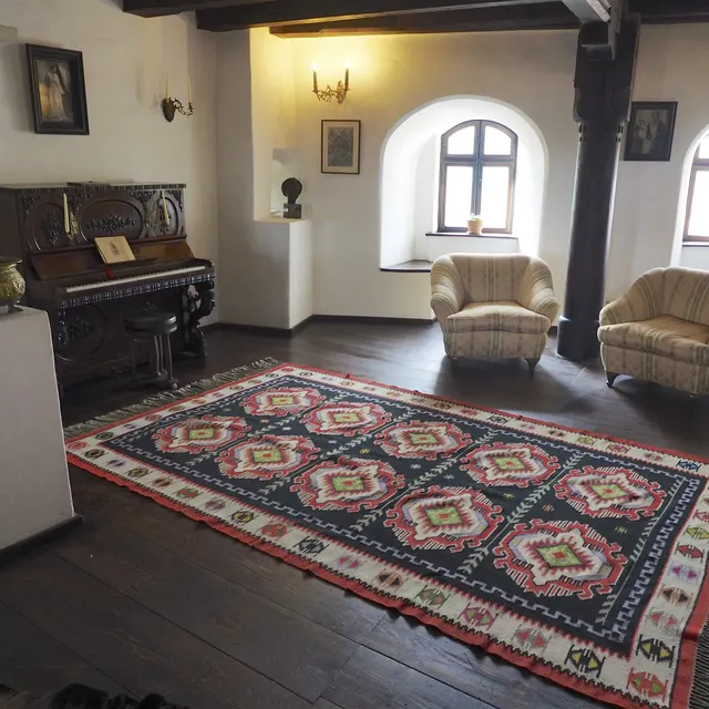 Queen Marie’s music room at Bran Castle with a piano and carpet